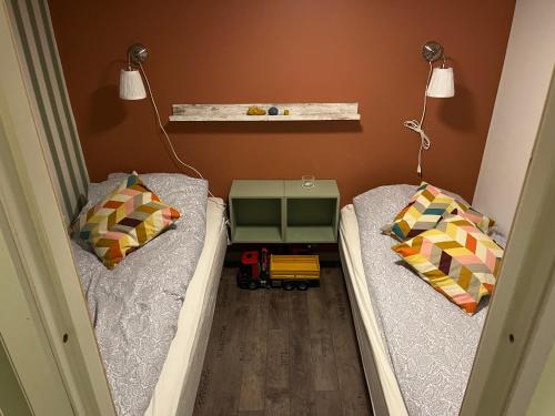 two beds in a room with a toy truck between them at Charming holiday home on the harbour (5 persons) in Rødvig