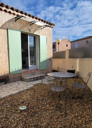 un patio avec une table et des chaises devant un bâtiment dans l'établissement Studio in quiet residence with pool, à Fréjus