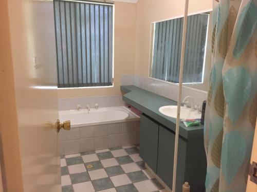 a bathroom with a bath tub and a sink at double room share bathroom and kitchen in Perth