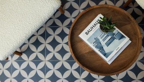 a book and a plant on a plate on a table at Albi Florentin - Traveler's Choice 2025 in Tel Aviv