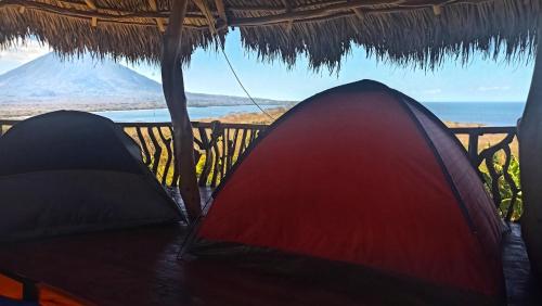 a tent sitting on a table with a view of the ocean at Hostel & Camping Sol Y Luna Ometepe in Balgue