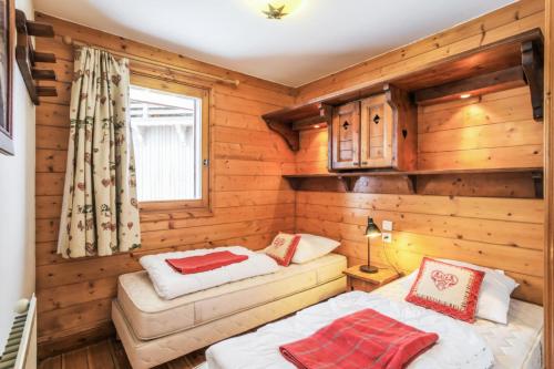 une chambre avec deux lits dans une cabane en rondins dans l'établissement Résidence Les Alpages de Reberty - maeva Home - Appartement 3 pièces 6 personnes Prestige MAE-0499, aux Menuires