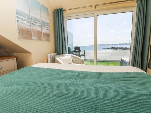 a bedroom with a bed and a view of the ocean at Higher Mount View in Marazion