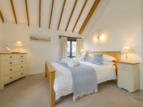een grote slaapkamer met 2 bedden en een raam bij Bramble Cottage in Bigbury