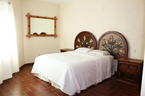 ein Schlafzimmer mit einem großen Bett und einem Spiegel in der Unterkunft BILBAO in Chiconcuac