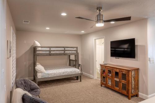 ein Schlafzimmer mit einem Etagenbett und einem Flachbild-TV in der Unterkunft Red Cliff Farmhouse in St. George