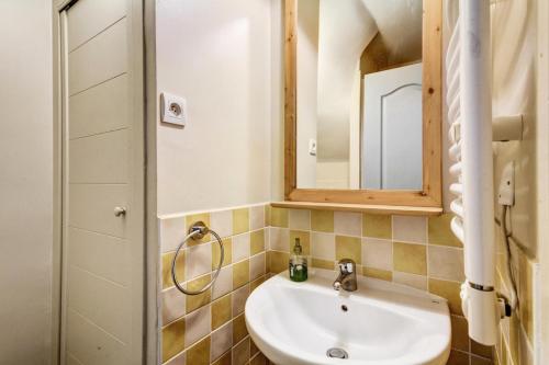 La salle de bains est pourvue d'un lavabo et d'un miroir. dans l'établissement Résidence La Marelle et Le Rami - maeva Home - Appartement 3 pièces 7 perso 20, à La Plagne Tarentaise
