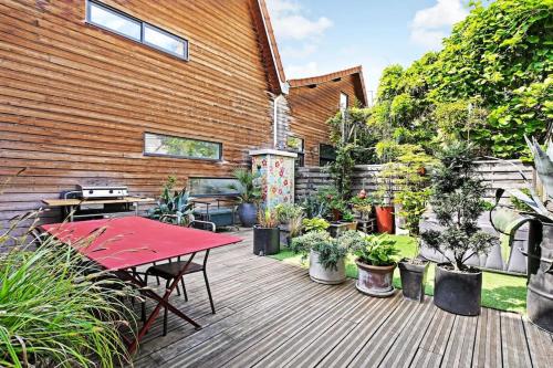 een patio met een rode tafel en potplanten bij Loft d'artiste, exceptionnel. in La Courneuve