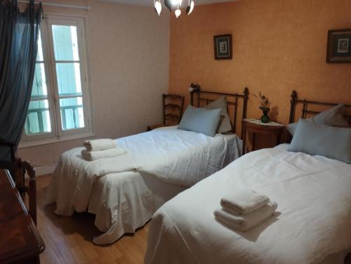 une chambre avec deux lits avec des serviettes dessus dans l'établissement Aux chambres du bourg, à Saint-Avit-Sénieur