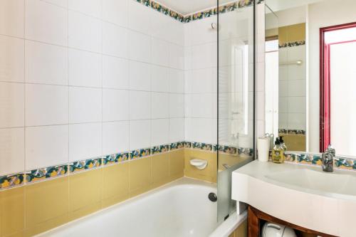 une salle de bain avec une baignoire et un lavabo dans l'établissement Résidence Le Mont Soleil - maeva Home - Appartement 2 pièces 4 personnes Confort MAE-2057, à Mâcot La Plagne