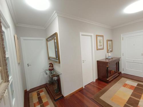 a living room with white walls and wooden floors at Apartamento Plaza in Caldas de Reis