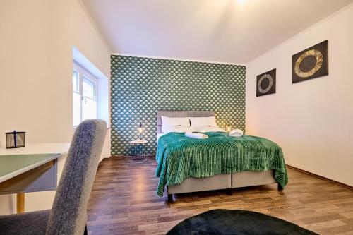 a bedroom with a bed with a green blanket at apanoxa homes I zentral I Bahnhof in Straubing
