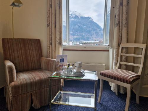 a room with a table and a chair and a window at Hotel Du Lac in Interlaken