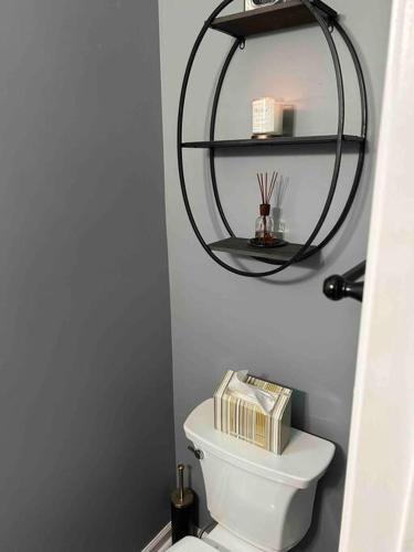 a bathroom with a toilet with a round shelf above it at Airport Home in Union City