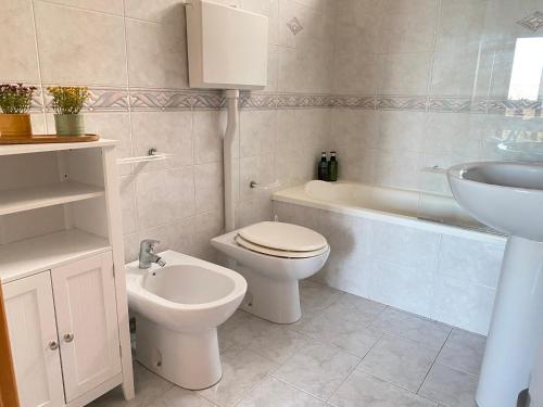 y baño con aseo, lavabo y bañera. en Villa Mare Giuggiola, en Alcamo Marina