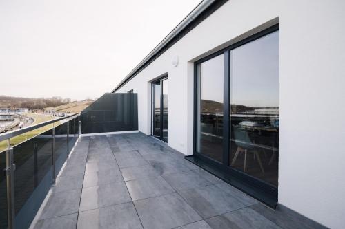 a balcony of a building with large glass windows at FeWo Backbord in Braunsbedra