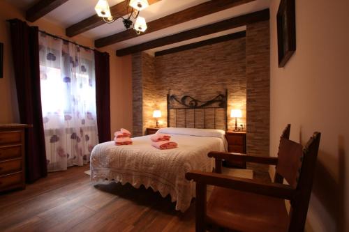 Un dormitorio con una cama con toallas rosas. en La Esquina de Animas, en La Alberca
