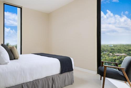 a bedroom with a bed and a large window at UXUE Villa 4 BR in Long Bay Hills