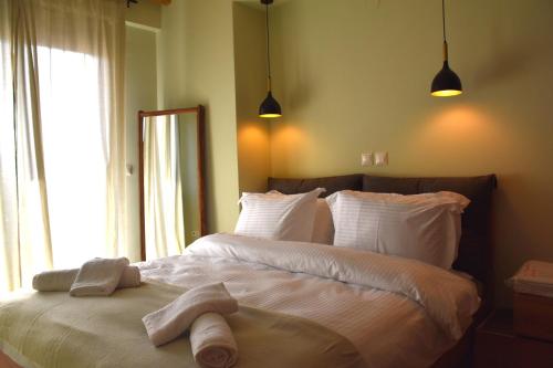 sypialnia z dużym łóżkiem z ręcznikami w obiekcie TheAretsouPlace, Kalamaria w Salonikach