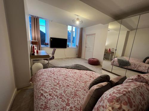 1 dormitorio con cama, escritorio y espejo en Duplex en plein cœur de ville en Moulins