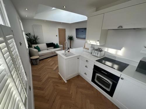 a kitchen with white cabinets and a living room at Apartment in Barnard Castle in Barnard Castle
