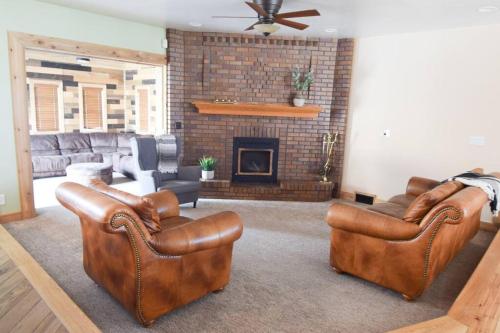 a living room with two leather couches and a fireplace at 6 King Bedrooms, Sleeps 20, 8 Rooms, Bikes, HotTub in Lindon