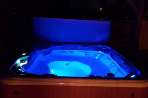 a blue bath tub in a dark room at 6 King Bedrooms, Sleeps 20, 8 Rooms, Bikes, HotTub in Lindon