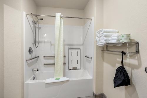 ein Bad mit einer Badewanne und einer Dusche mit Handtüchern in der Unterkunft Cobblestone Hotel & Suites - Lynden in Lynden