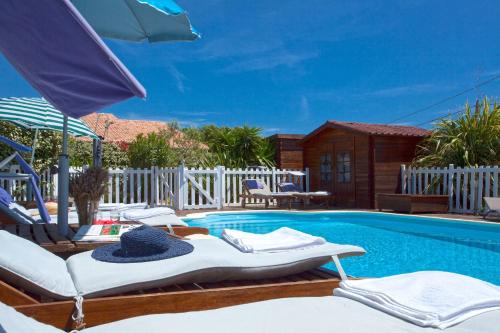 a swimming pool with lounge chairs and an umbrella at Residence Agula Mora in Lecci