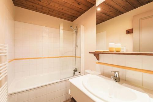 y baño con lavabo, bañera y aseo. en Quartier La Forêt - maeva Home - Appartement 3 pièces 6 personnes Sélectio 26 en Valmorel