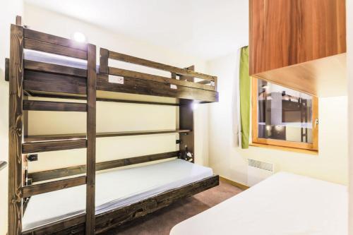 Cette chambre dispose de lits superposés, de deux lits et d'une fenêtre. dans l'établissement Résidence Les Temples du Soleil - maeva Home - Appartement 2 pièces 5 personnes Confort MAE-7729, à Val Thorens