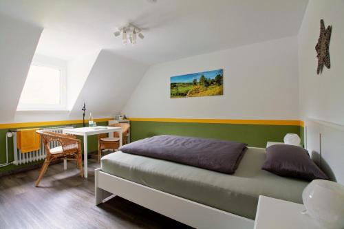 a bedroom with a bed and a desk and a table at Toms Gästehaus in Schleiden