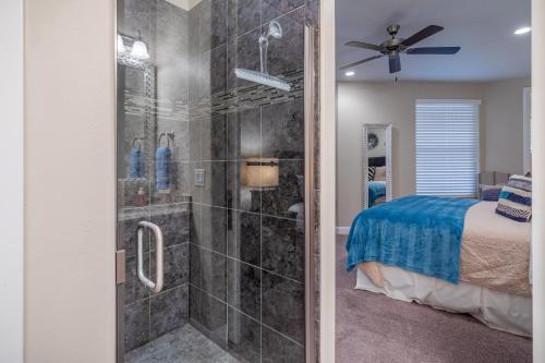 a bathroom with a walk in shower next to a bed at Hoodoo Haute in St. George