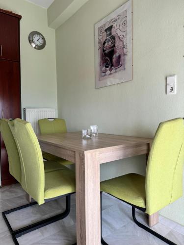 a dining room table with green chairs in a room at Sofias Ferienhaus in Kavala