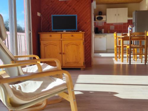 Domaine de la roselière • Nature • Brenne في Rosnay: غرفة معيشة مع تلفزيون على خزانة خشبية