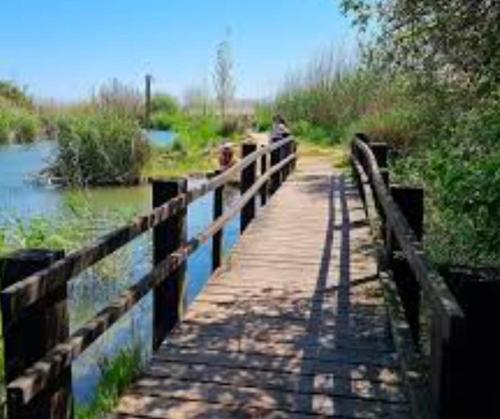 a wooden bridge over a river with a fence at Reina in Pego