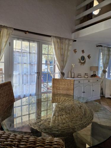 une salle à manger avec une table et des chaises en verre dans l'établissement Elegant Studio Close to the Sea, à Sainte-Maxime