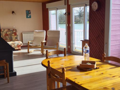 a living room with a wooden table and chairs at Domaine de la roselière • Nature • Brenne in Rosnay