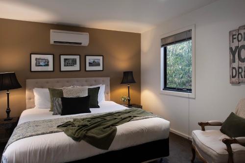 um quarto com uma cama grande e uma janela em Alofi em Hepburn Springs