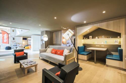 uma sala de estar com um sofá, cadeiras e uma mesa em Résidence Premium L'Hévana - maeva Home - Appartement 3 pièces 7 personnes 55 em Les Allues