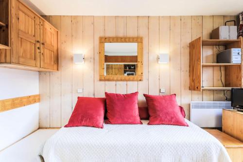 une chambre avec un grand lit avec des oreillers rouges dans l'établissement Résidence Les Brigues - maeva Home - Appartement 2 pièces 6 personnes Confort MAE-7008, à Courchevel