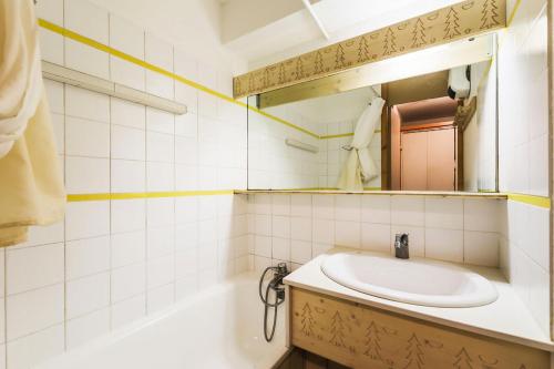 une salle de bain avec un lavabo et un miroir dans l'établissement Résidence Les Brigues - maeva Home - Appartement 2 pièces 6 personnes Confort MAE-6259, à Courchevel