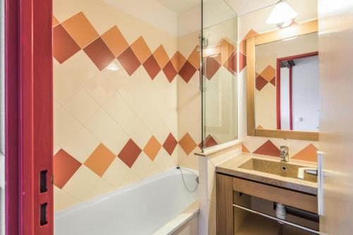 une salle de bain avec une baignoire et un lavabo dans l'établissement Résidence Les Fontaines Blanches - maeva Home - Appartement 2 pièces 7 personnes Confort MAE-7285, à Morzine