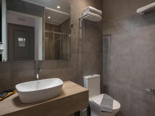 a bathroom with a sink and a toilet at Hotel Grand TuCasa Near International Airport in New Delhi