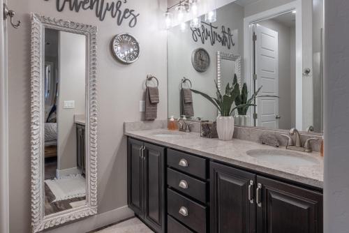 a bathroom with a large mirror and a sink at Sunny 3-Bedroom Villa in St. George