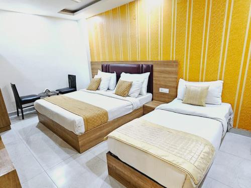 um quarto de hotel com duas camas e uma secretária em Hotel Grand TuCasa Near International Airport em Nova Deli