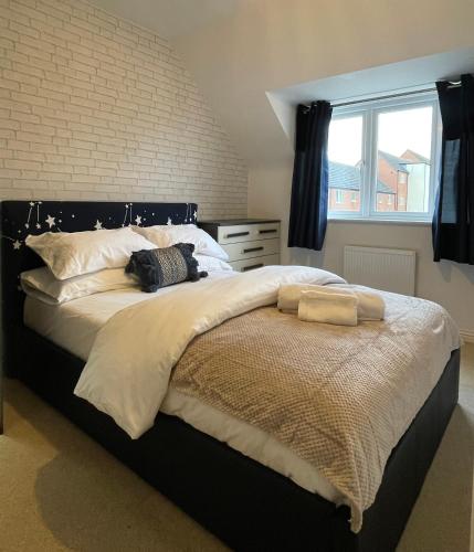 a bedroom with a large bed with white sheets and a window at Holcott's Coach-House in Lincoln