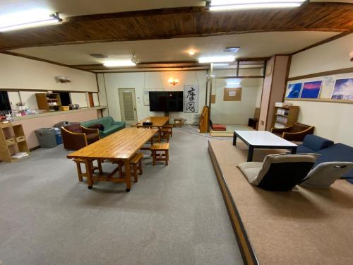 ein großes Zimmer mit Tischen und Stühlen in der Unterkunft Mashuko Youth Hostel - Vacation STAY 00138v in Teshikaga