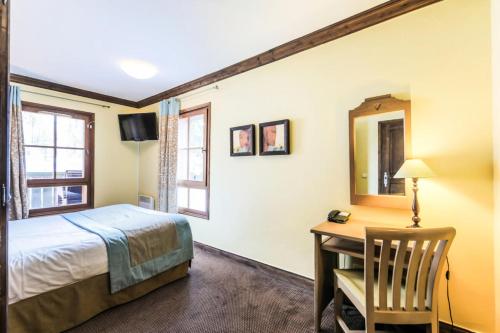 une chambre avec un lit, un bureau et un miroir dans l'établissement Résidence Les Arcs 1950 Le Village - maeva Home - 3 pièces 6 personnes Sélection - Manoir de Savoie MAE-8121, à Bourg-Saint-Maurice