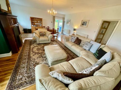 a living room with couches and a rug at Spacious Garden Flat in Snowdonia National Park in Brynkir